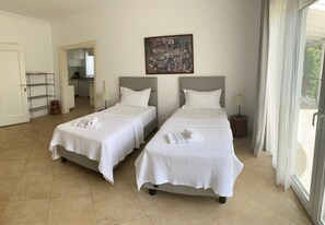 A hotel room with two beds, a painting on the wall, and a view through the window. - Villa White (Datça)
