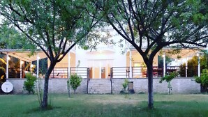 A house with a stone wall, a satellite dish, and a covered outdoor area. - Villa White (Datça)