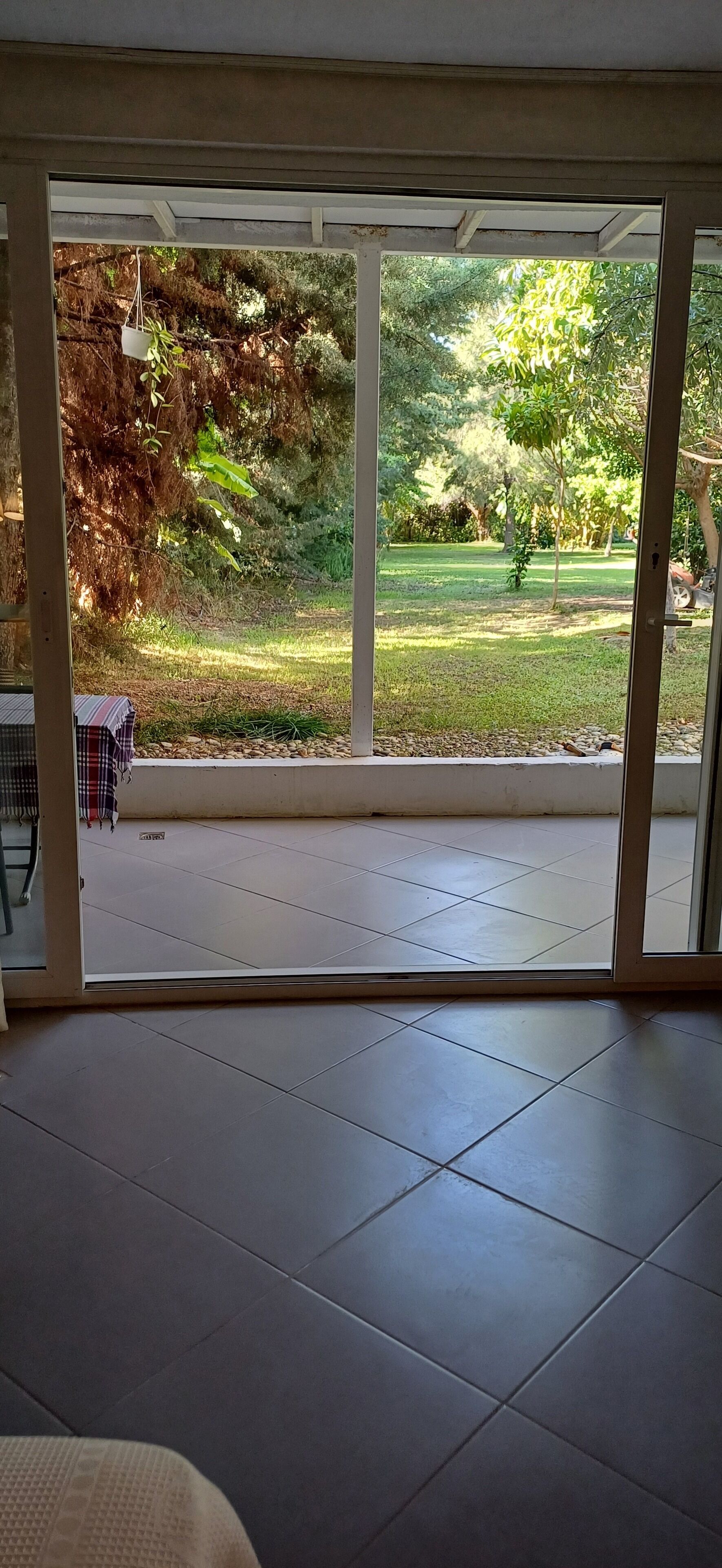 Una habitación con puerta corrediza de vidrio que da a un jardín.