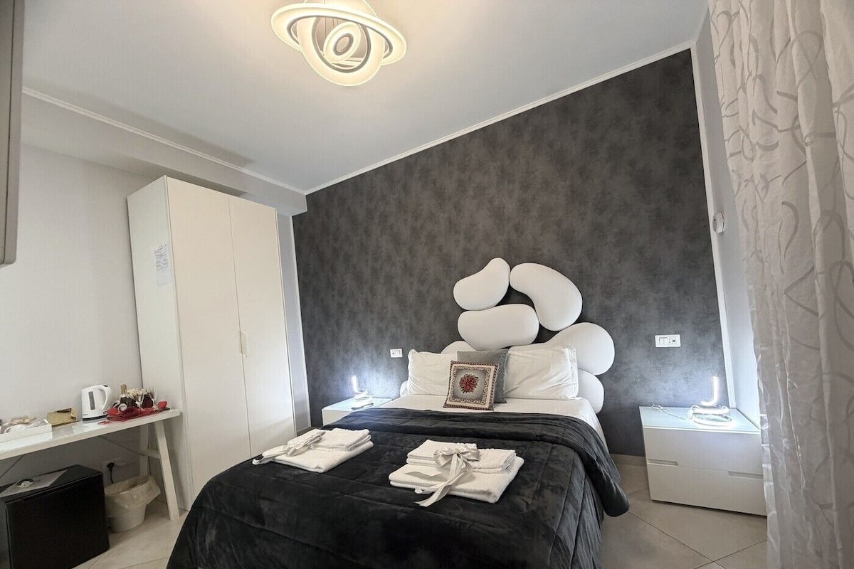 Ein modernes Schlafzimmer mit einem großen Bett, einem Nachttisch, einem Kleiderschrank und einem einzigartigen Wandbild.