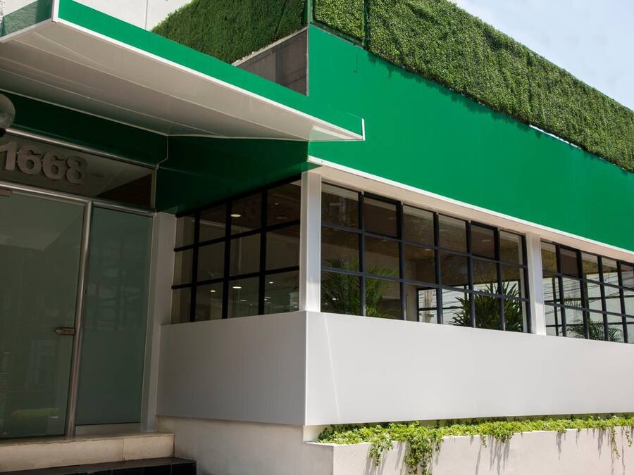 A modern building with a green facade, large windows, and a visible address number 1668.