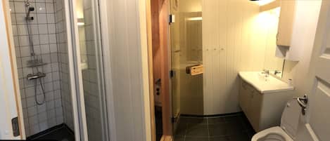 A bathroom with a shower, toilet, and sink.