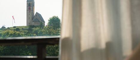 A person reaching into a hot tub with a view of a building in the background.