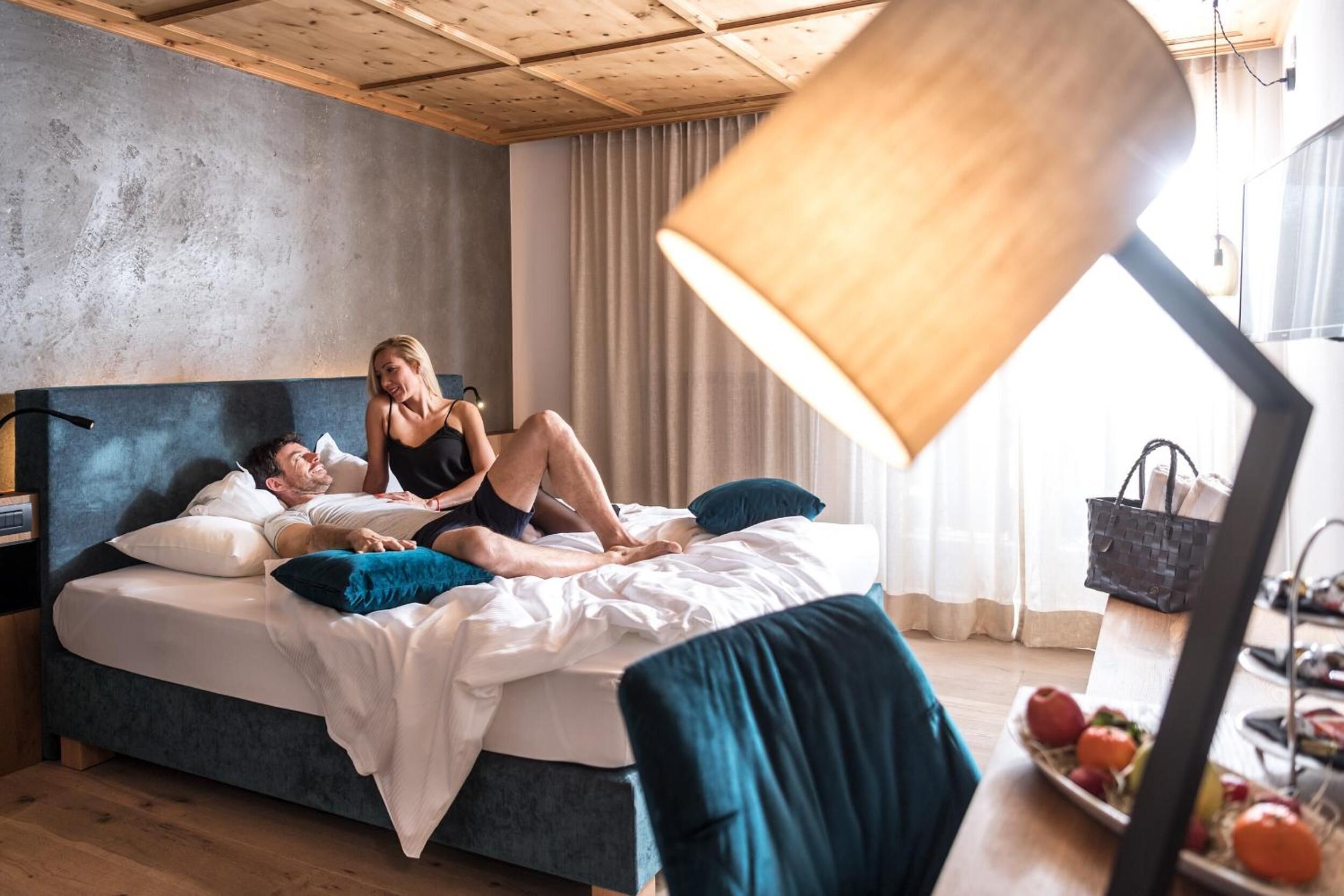 Ein Schlafzimmer mit einem Bett, einem Nachttisch, einer Lampe und einer Obstschale auf einem Tisch.