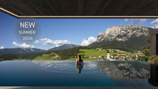 A person in a pool with a scenic mountain view.