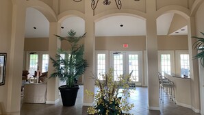 A spacious lobby with high ceilings, a chandelier, and multiple seating areas.