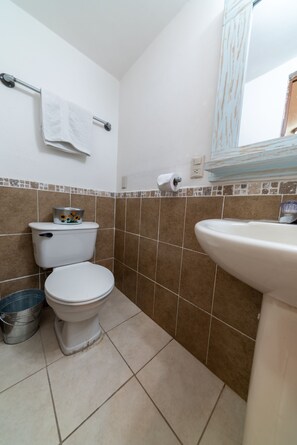 Een badkamer met toilet, wastafel en bidet.