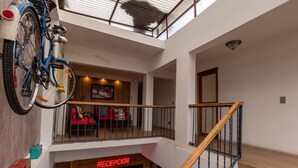 Un intérieur à plusieurs niveaux comprenant un escalier, un espace d’accueil et un vélo fixé au mur.