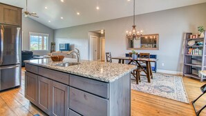 A spacious kitchen with granite countertops, wooden cabinets, and a central island. - Wild Cat Cabin - Hot Tub - Foosball - Near Resort (Driggs)