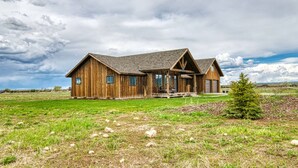 A rustic wooden house with a large porch and a garage. - Wild Cat Cabin - Hot Tub - Foosball - Near Resort (Driggs)