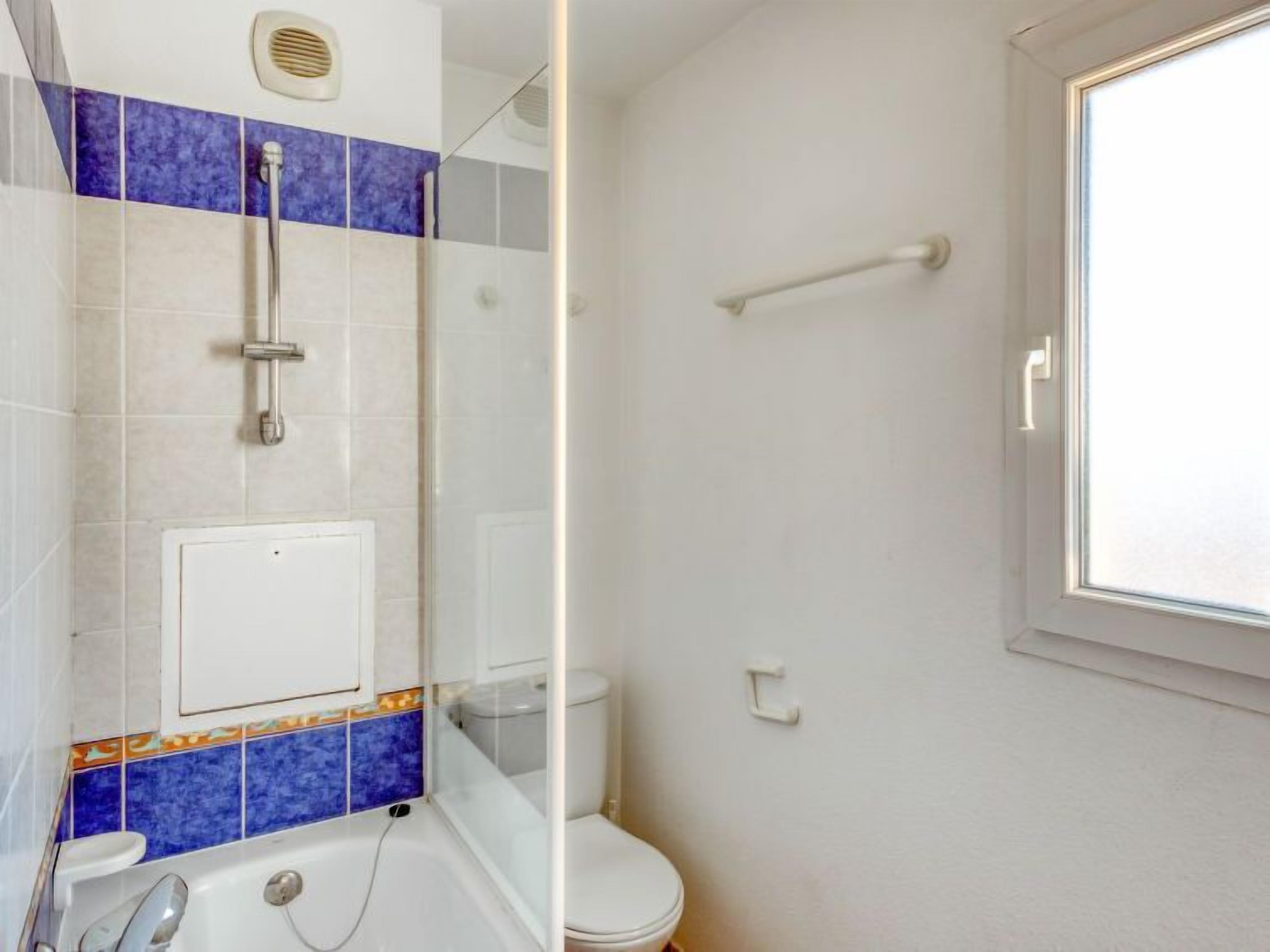 Un baño con bañera, ducha e inodoro.