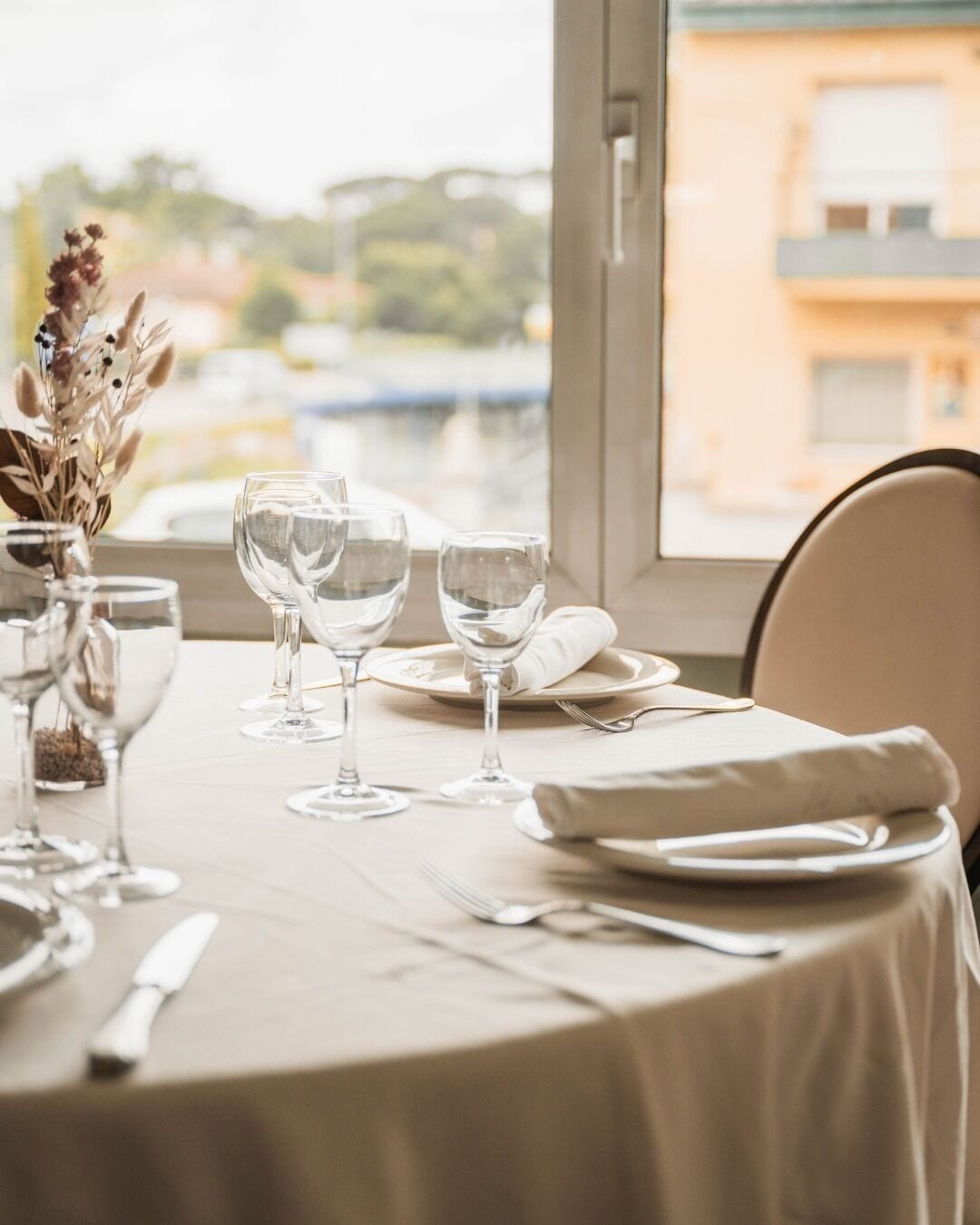 A table set for dining with a view of buildings outside.