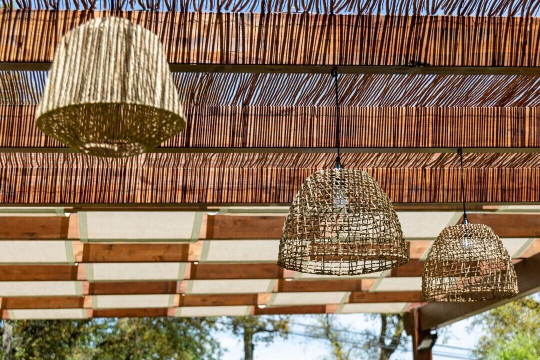 Uma pérgola com luminárias trançadas no teto.