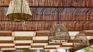 Uma pérgola com luminárias trançadas no teto.