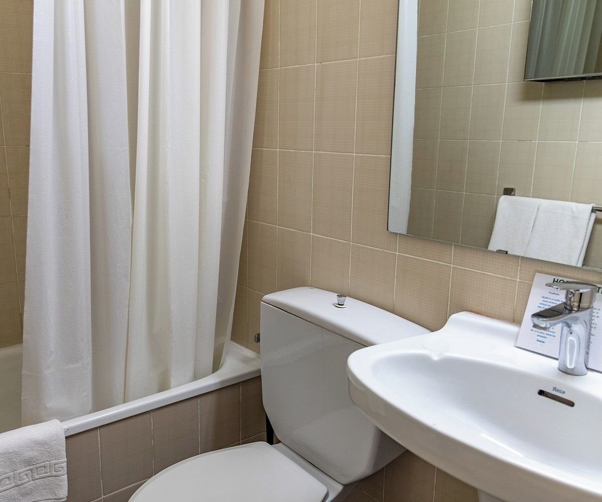Un baño con inodoro, lavamanos y bañera.