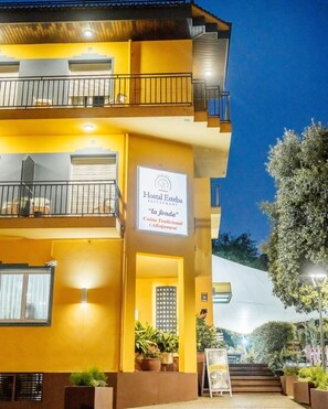 A two-story building with a sign for 'Hostal Esteva Restaurant' and a balcony with railings. - Hostal Esteba (Caldes de Malavella)