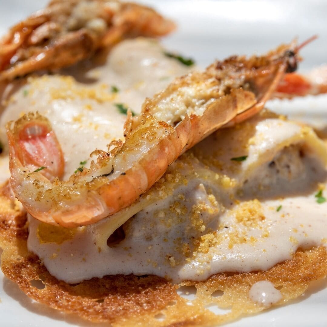 Un plato de comida con camarones y un huevo escalfado.