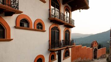 A building with multiple balconies, arched windows, and a stone entrance.