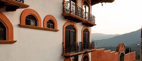 Un edificio con varios balcones, ventanas en arco y una entrada de piedra.