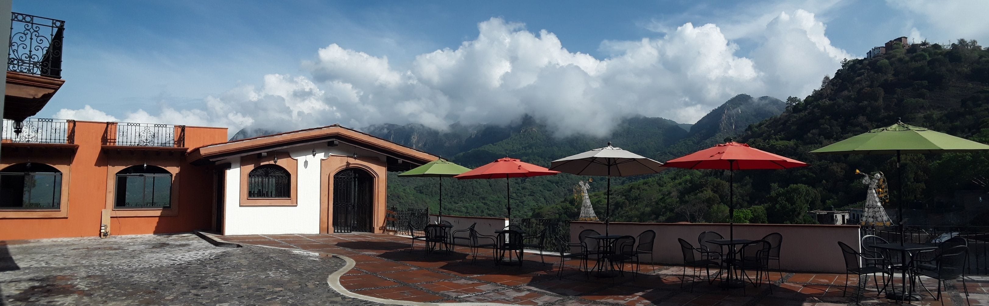 A terrace with outdoor seating and a view of mountains.