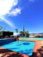 Una piscina al aire libre, sillones reclinables de piscina