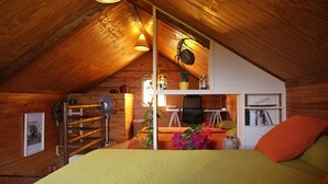 Une chambre confortable située dans les combles, avec un lit, un bureau et une chaise.