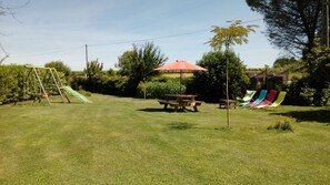 A grassy outdoor area with a swing set, picnic table, and colorful chairs. - Lodging near Amboise, Chenonceau, Chaumont / Loire  (Mosnes)