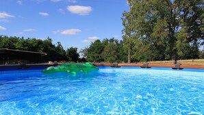 A clear blue pool with a green inflatable object, surrounded by trees and a clear sky. - Lodging near Amboise, Chenonceau, Chaumont / Loire  (Mosnes)