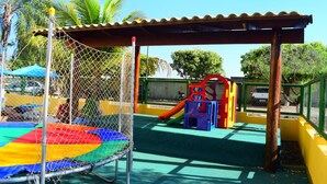 A playground with a trampoline, slides, and a covered area. - Thermas Place - Férias em Caldas Novas (Caldas Novas)
