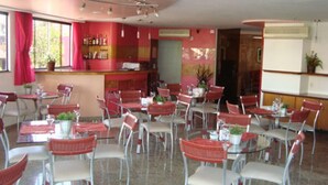 A dining area with tables and chairs, a bar area with bottles, and a counter.