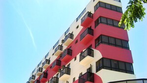 A multi-story building with balconies and large windows.