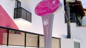A hotel sign with the name 'Rosa Mar' and a stylized female figure.