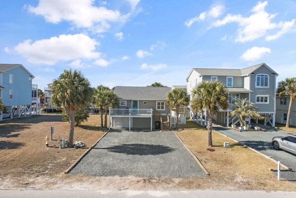 A residential area with houses, a driveway, and a parked car.