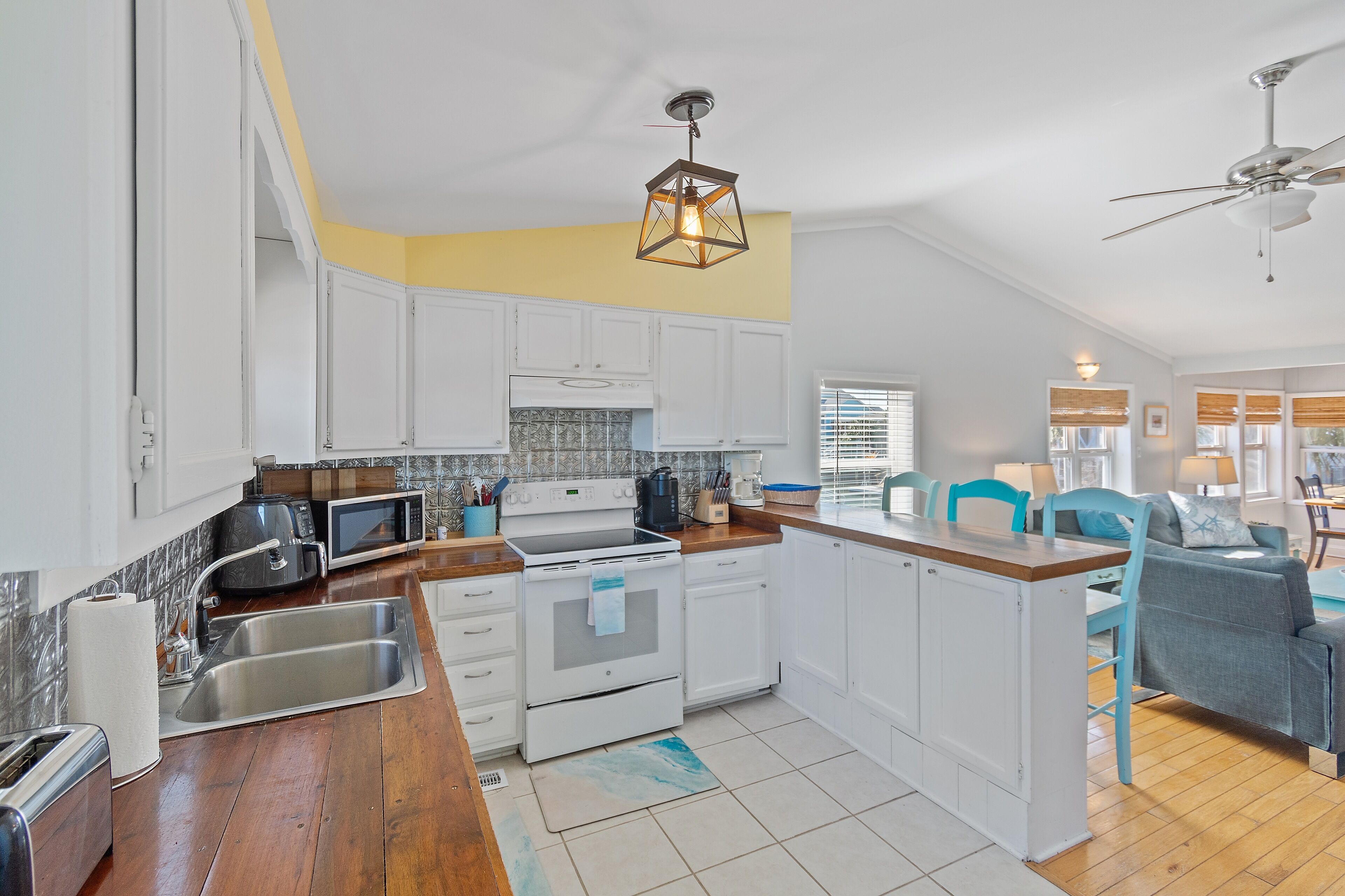 A modern kitchen with white cabinets, a wooden countertop, and a built-in oven.