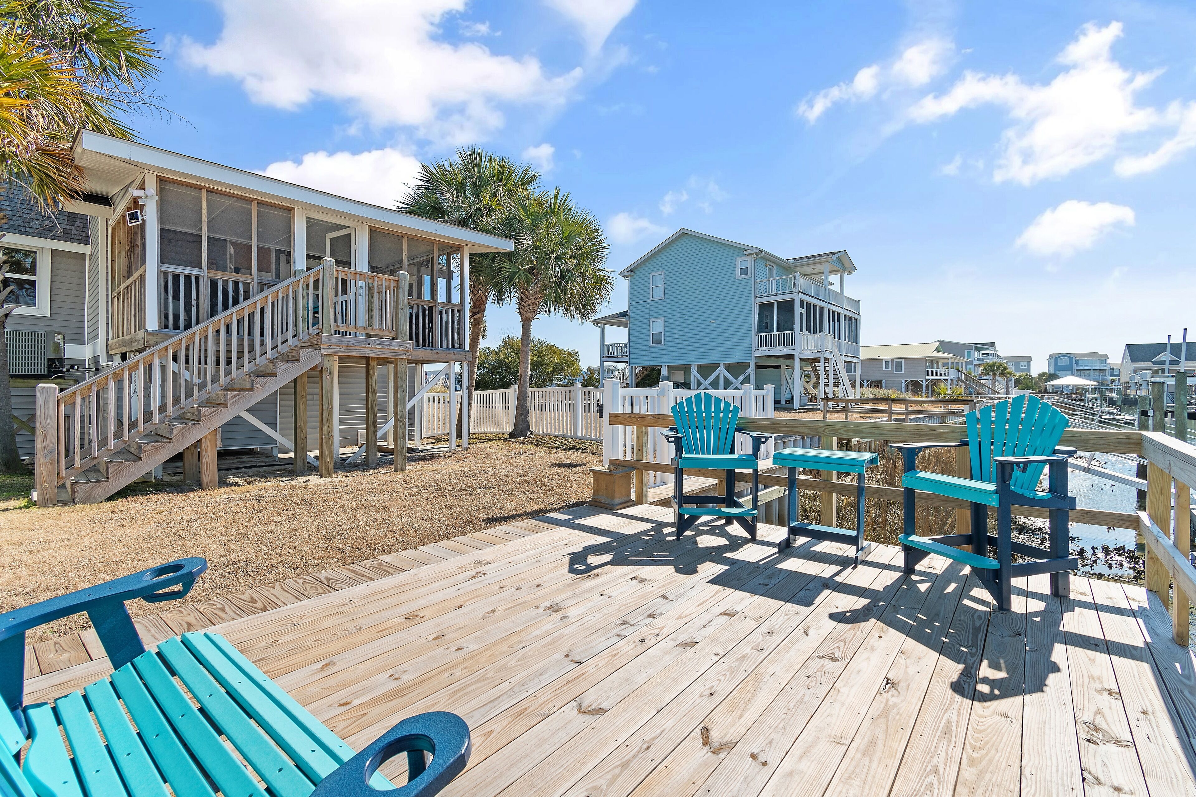 A wooden deck with a pool table, chairs, and a small pool.