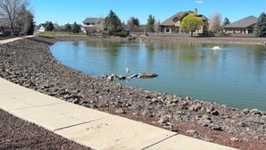 A serene pond with a walking path, surrounded by residential houses and trees. - Mountain Retreat - Close to NAU & Snowbowl (Bellemont)