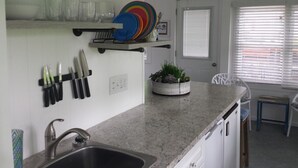 A kitchen with a granite countertop, a sink, and a window with blinds. - Adorable Cottage Townline Lake Paradise. Boat Kayak Fish BBQ Relax Swim. 2 BR  (Lakeview)