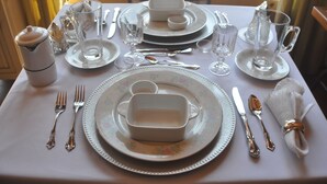 A table set for a meal with plates, bowls, cutlery, glasses, and a pitcher. - Au domaine de La Giroux-ette (La Patrie)