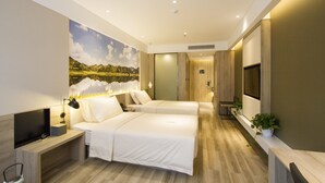 Quarto de hotel moderno com duas camas, televisão de tela plana, escrivaninha e uma grande pintura de paisagem na parede.