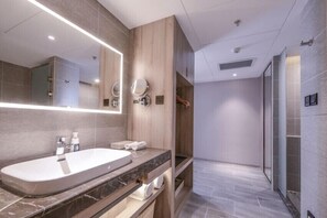 A modern bathroom with a large mirror, a bathtub, and a shower area. - Atour Hotel Museum Harbin (Harbin)
