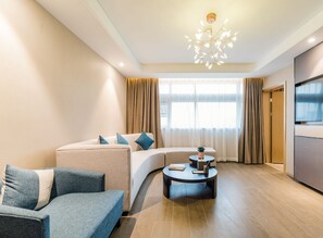 A modern living room with a sofa, a coffee table, and a TV. - Atour Hotel Museum Harbin (Harbin)