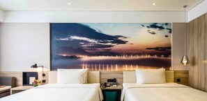 A hotel room with two beds, a large painting of a sunset over water, and a wooden headboard. - Atour Hotel People's Square Xiaoshan Hangzhou (Hangzhou)