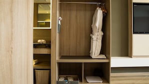 A wooden wardrobe with shelves, a hanging robe, and a laptop. - Atour Hotel People's Square Xiaoshan Hangzhou (Hangzhou)