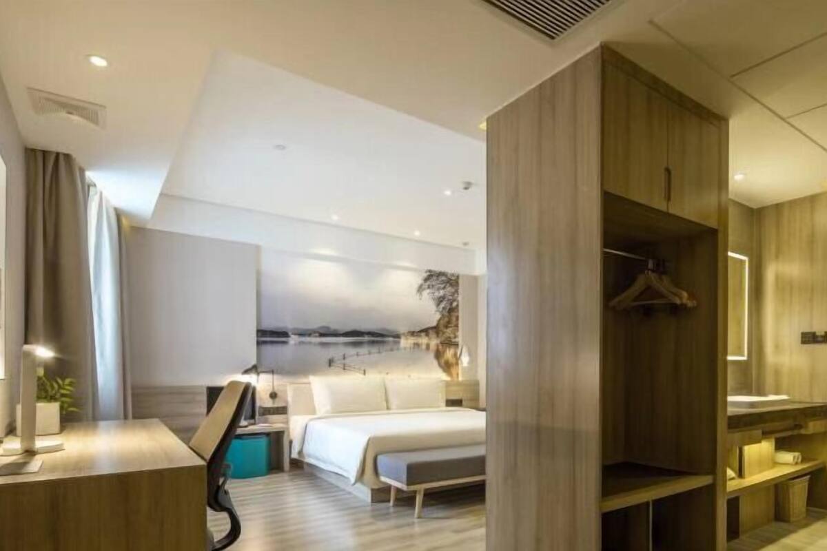 Ein modernes Hotelzimmer mit Bett, Nachttisch und Seeblick.