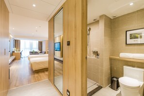 A modern hotel room with a wooden floor, a large bed, a TV, a shower, and a toilet. - Atour Hotel West Lake Cultural Square Shangtang Rd Hangzhou (Hangzhou)