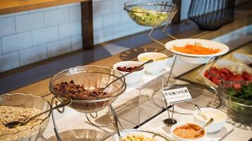 A buffet with various food items and condiments, including a bowl labeled "cornmeal" and a sign indicating "gravy."