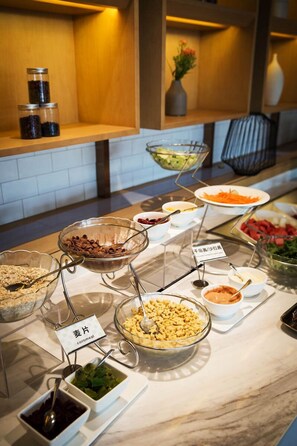 A buffet with various food items and condiments, including a bowl labeled "cornmeal" and a sign indicating "gravy." - Atour Hotel Tianyi Square Ningbo (Ningbo)