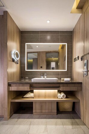 A modern bathroom with a large mirror, a sink, and a vanity with storage. - Atour Hotel Tianyi Square Ningbo (Ningbo)