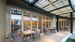 An outdoor patio area with wooden flooring, tables, and chairs. - Atour Hotel Tianyi Square Ningbo (Ningbo)