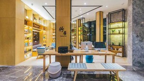 A modern reading club with wooden bookshelves, a central table, and seating areas. - Atour Hotel Tianyi Square Ningbo (Ningbo)